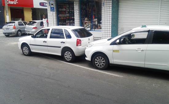 Esse Gol da frente está numa esquina e debaixo de uma placa informado 8 vagas para taxi.